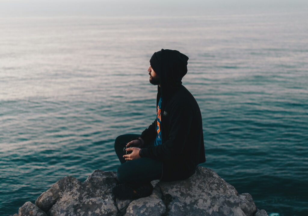 man sitting alone water