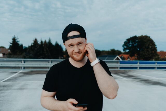 hipster man with hat on backwards outside