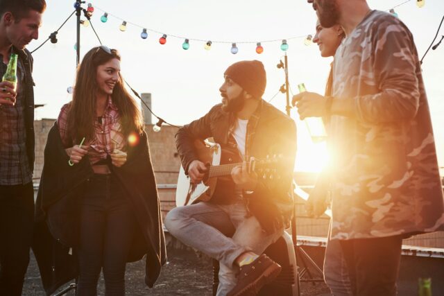 guy playing guitar at rooftop party