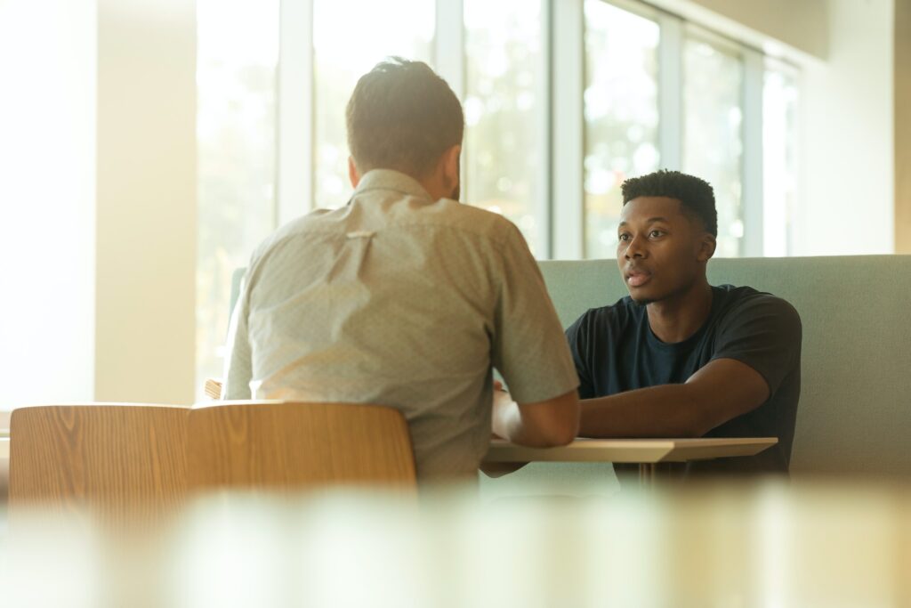 two men talking at table