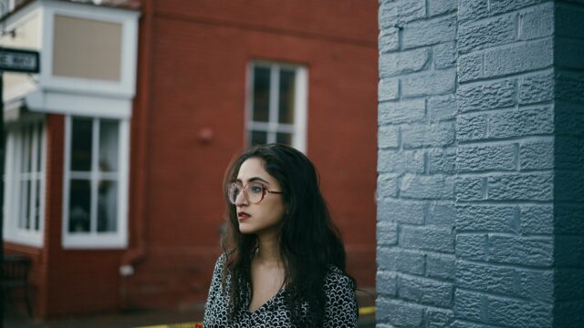 serious woman outside by brick wall