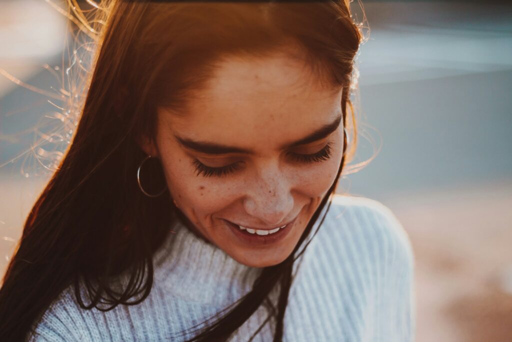 smiling woman looking down in sunshine