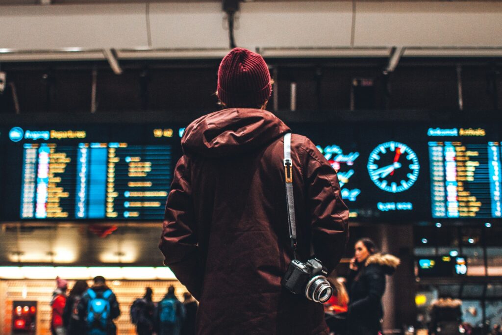 man in front of departures board