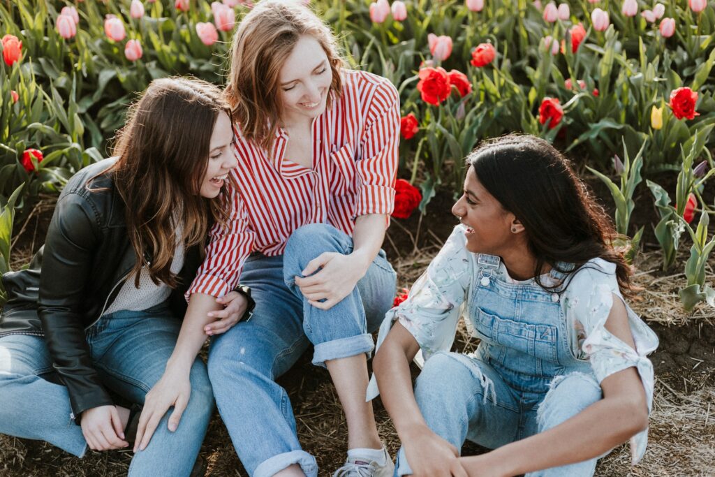 three friends talking outdoors in flowers